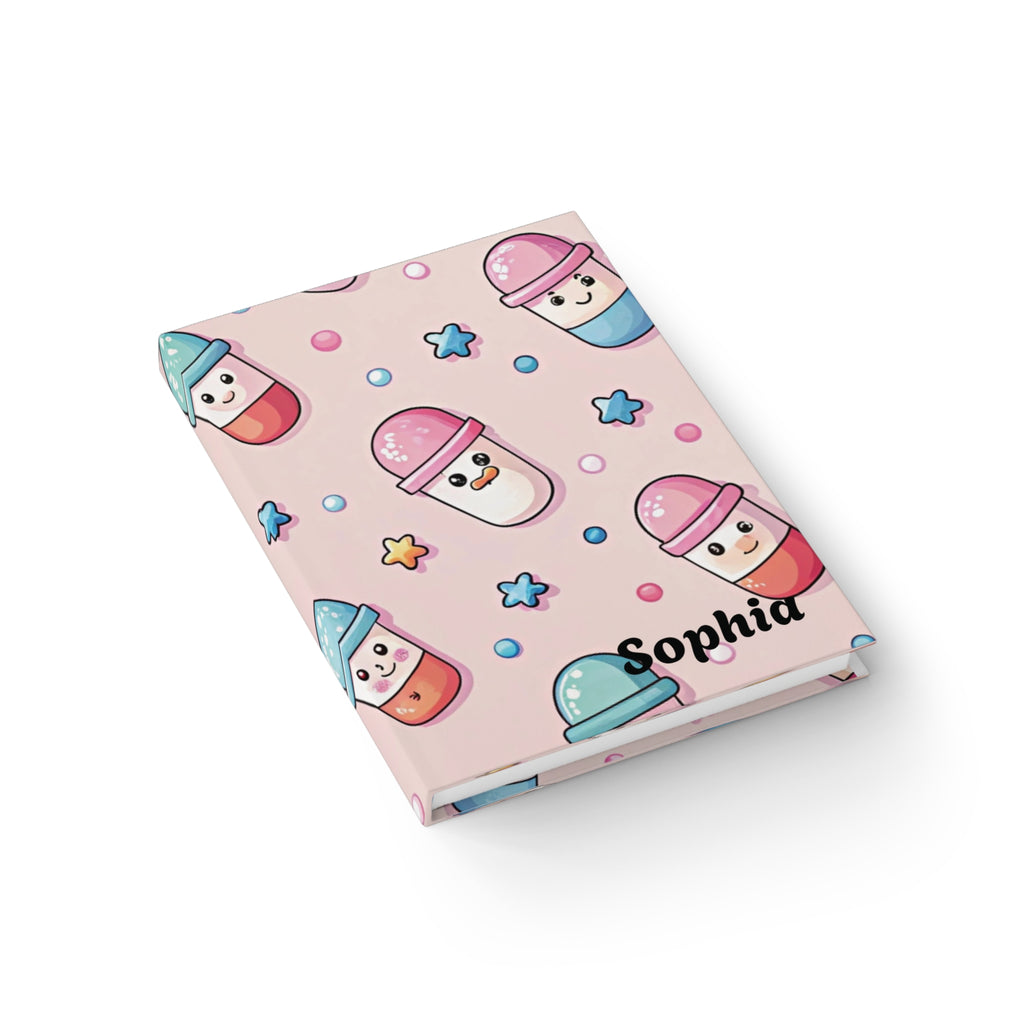 Kawaii pill journal lifestyle shot — personalised pink hardcover notebook with cute capsule character pattern
